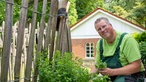 Michael Stücke erntet Kräuter im Garten. 