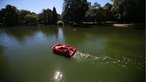 Ein Mann und ein Kind fahren mit einem Tretboot über einen Teich.