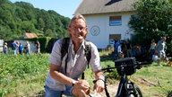 Frank Buchholz auf dem "Dorfacker", im Hintergrund holen Mitglieder ihr Gemüse ab. 