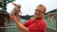 Jan Spliethofe mit einem kleinen Ferkel. 