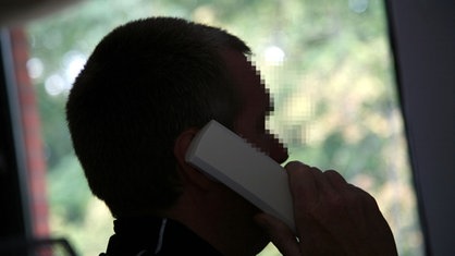 Verpixelter Mann am Telefon.