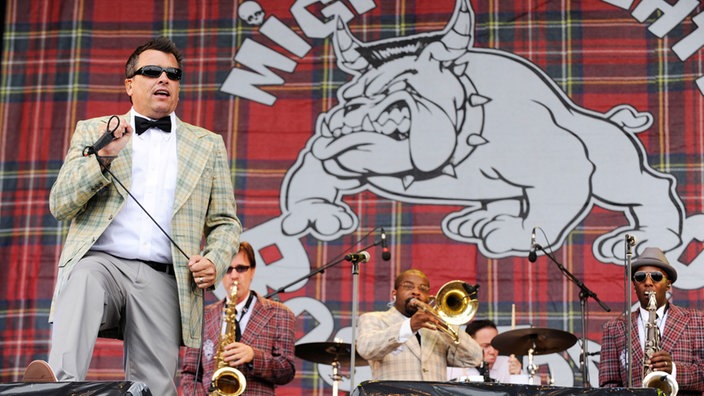 Das Outfit der Mighty Mighty Bosstones besticht durch kräftige Karomuster. Die 6 Bandmitglieder tragen Sonnenbrillen