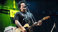 Bandmitglied von Nofx singt und spielt Gitarre auf der Bühne