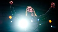 Sänger Myles Kennedy von der Band Alter Bridge hebt die Arme hoch