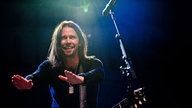 Myles Kennedy, Sänger der Band Alter Bridge, streckt die Arme nach vorne und lacht