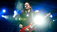 Sänger der Band Alter Bridge steht mit seiner Gitarre auf der Bühne