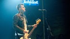 Bassist von The Gaslight Anthem entspannt auf der Bühne, im Hintergrund das Rockpalast Logo