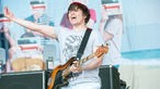 Bassist von The Wombats streckt die Hand zum Publikum und singt laut mit