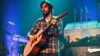 Der Sänger der "Band of Horses" steht mit Akkustik-Gitarre auf der Bühne