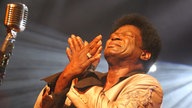 Aufnhamen von Charles Bradley mit gekreuzten Handflächen