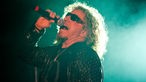 Sammy Hagar im Seitenprofil mit in den Nacken gelegtem Kopf und Mikrofon am Mund