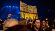 Publikum mit hochgehaltenem Schild, auf dem "Burn down Fucking LA" steht.