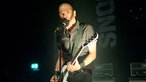 Danko Jones ist im Licht eines Spotlights am performen.