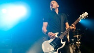 Danko Jones sieht während dem spielen in die Menge.