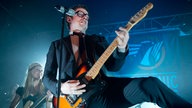 Bernhoft rockt auf seiner elektrischen Gitarre, das Gesicht angestrengt verzogen, ein Bein in die Luft geworfen.