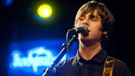 Jake Bugg on stage - im Hintergrund leuchtet das Rockpalast-Logo.