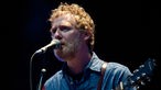 Glen Hansard, Sänger mit roten Locken und Bart, singt ins Mikro und spielt Akustikgitarre.