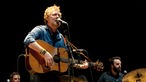 Glen Hansard singt mit geschlossenen Augen und spielt Gitarre