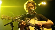 Ben Howard spielt auf der Akkustik-Gitarre während er dazu singt