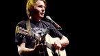 Ben Howard zupft die Saiten seiner Gitarre und singt dazu