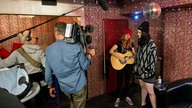 Kate Nash steht mit einer Gitarristin im Backstagebereich und spielt ein Unplugged für die Kamera des Rockpalastes.