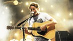 ben howard strummt die Gitarre sanft und singt dabei