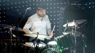 Der Drummer der Gruppe, der hinter seinem grünen Schlagzeug sitzt