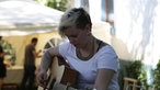 Rah Rah spielt einen Unplugged Song, junge Frau spielt Gitarre