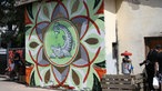 Auf einer Gebäudeaußenwand ist das Symbol des Orange Blossom Festivals aufgemalt, es ist ein schuppiger Fisch zu sehen der in seiner Schwanzflosse eine Flasch hält und dessen Inhalt in sein Maul kippt