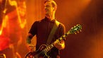 Gitarrist der Beatsteaks spielt einen Emoll Akkord im 7. Bund seiner Gibson Les Paul und schaut stimmungsvoll Richtung Sänger