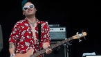 Bassist der Me First & The Gimme Gimmes spielt und blickt glücklich Richtung Publikum