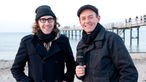 Martin Gretschmann von The Notwist und Manuel Unger stehen zusammen am Strand