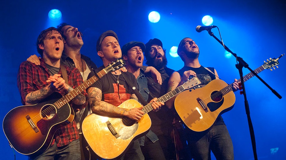 Alle Mitglieder der Band zusammen bei einer Art Chorgesang