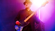 Bassist mit Hut im violetten Lichtschein