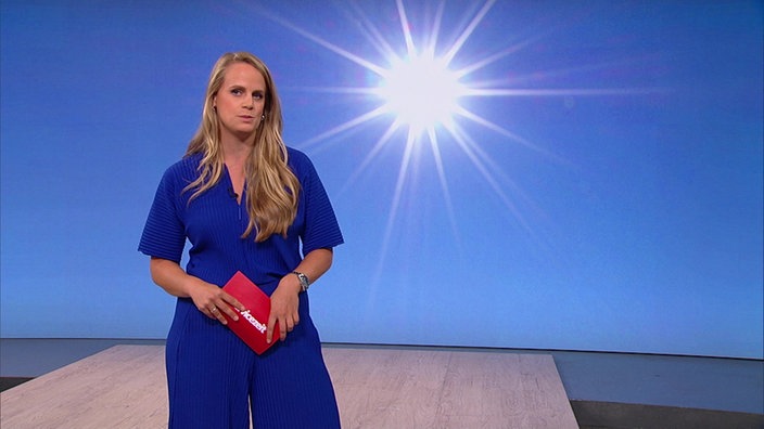 Svenja Kellerhohn steht im Servicezeit-Fernsehstudio. Im Hintergrund sieht man eine strahlende Sonne.