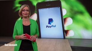 Die Moderatorin im Studio vor dem Bild eines Handys mit der geöffneten Paypal-App