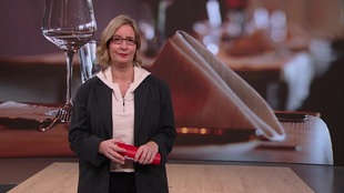 Die Moderatorin steht im Fernsehstudio.