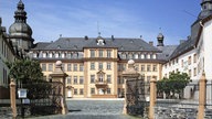 Blick durch ein Eisentor Tor auf den Hof und das Schloss Berleburg