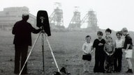 Bernd Becher beim Fotografieren im nordenglischen Bergbaurevier im Jahre 1968, aufgenommen von seiner Frau Hilla Becher. 