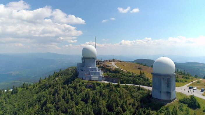 Zwei Radome mit runder, weißer Kuppel auf einem Berggipfel