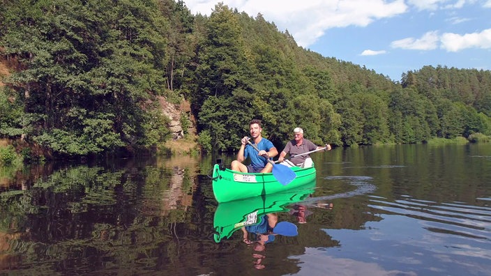 Ramon Babazadeh und ein weiterer Mann paddeln in einem Kanu auf dem Fluss Regen