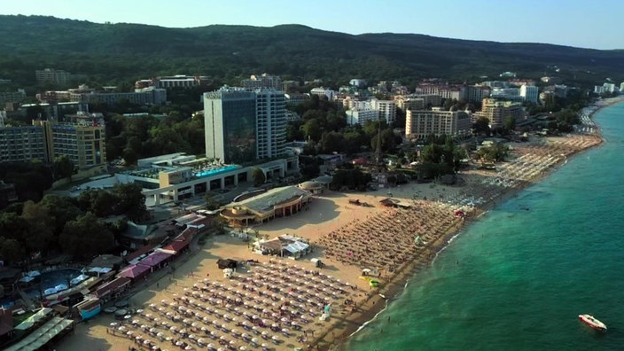 Hotelburgen an langem Sandstrand mit vielen Sonnenliegen