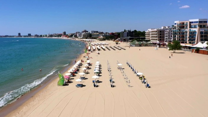 Langer, breiter Sandstrand, dahinter Hotelanlagen