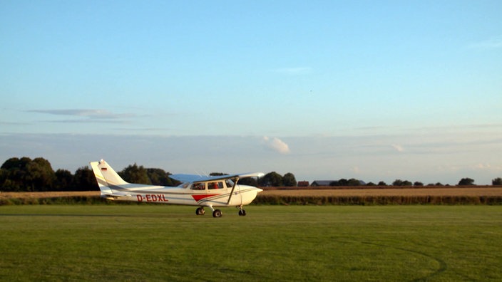 Kleines Sportflugzeug startet auf einer Wiese