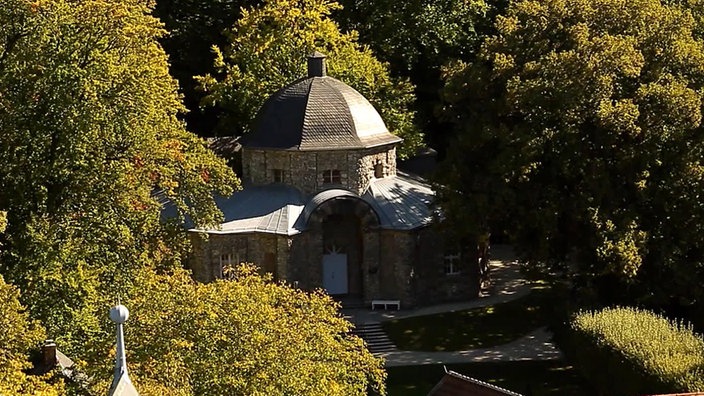 Kleines rundes Schlossgebäude inmitten von Bäumen