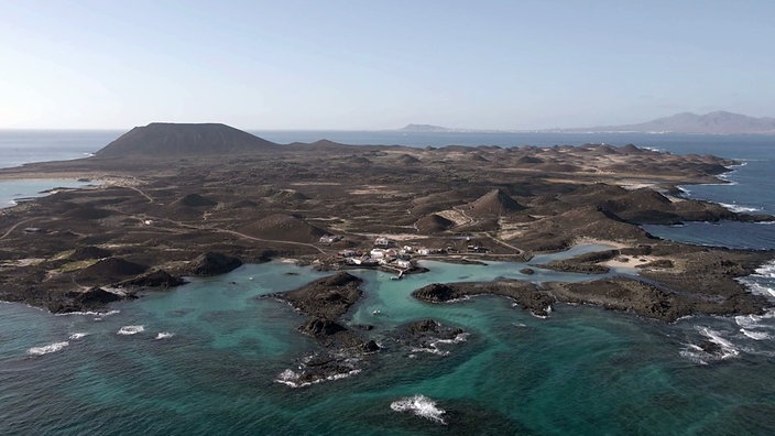 Luftaufnahme einer kargen Insel mit ein paar Häusern