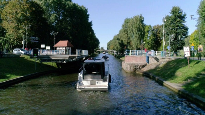 Schiff auf einem Kanal fährt durch eine geöffnete Brücke