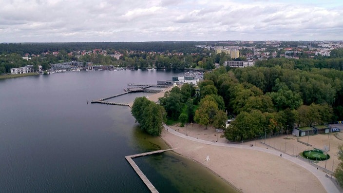 Blick auf See mit Stränden, Wald und Wohnbebauung