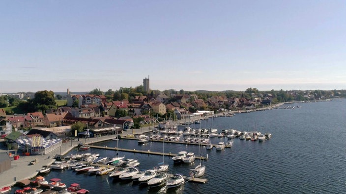 Blick auf See mit Yachthafen und eine Stadt