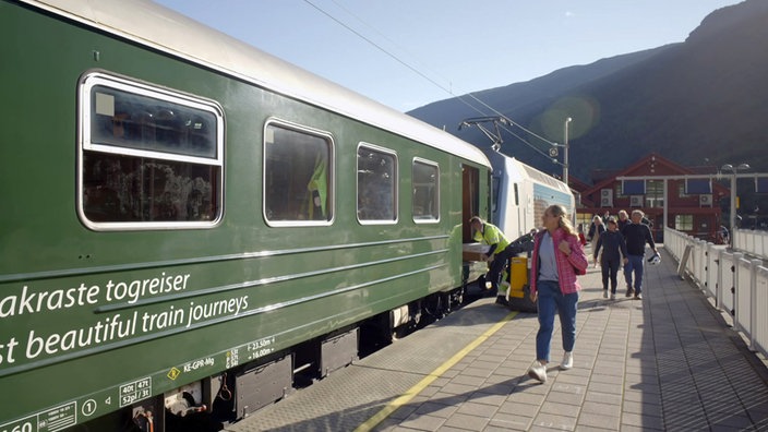 Tamina Kallert steht auf dem Bahnsteig vor einem Wagen der  Flåmsbahn